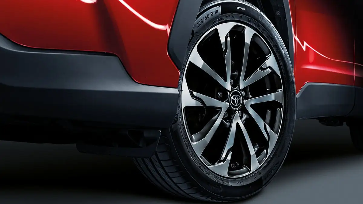 Detail shot of Toyota Corolla Cross wheel featuring 18" alloy rim and premium tire branding