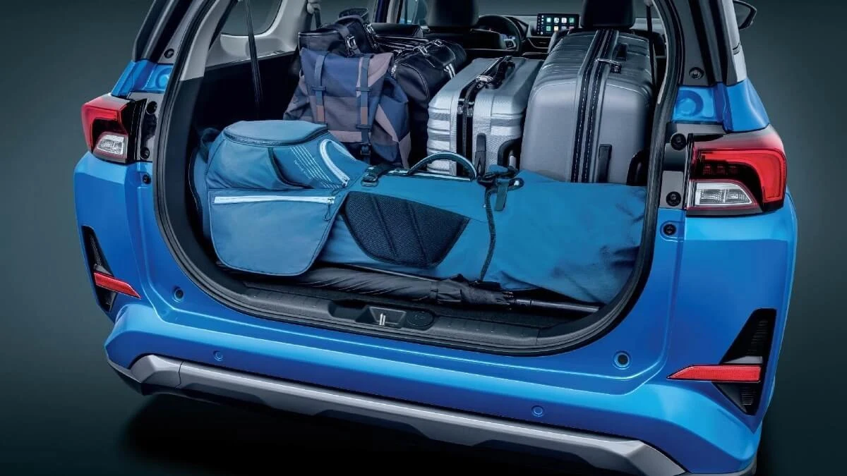 Blue Toyota Veloz open tailgate displaying generous cargo space with multiple bags demonstrating storage capacity