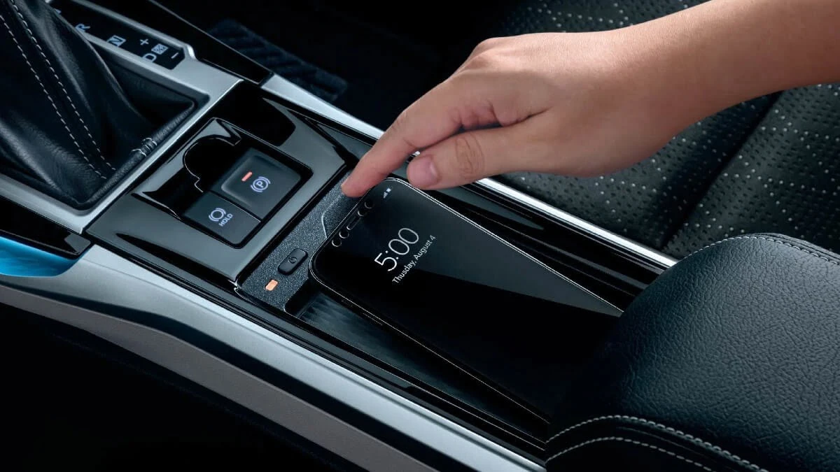 Toyota Veloz interior featuring wireless charging pad with smartphone being placed for convenient device charging