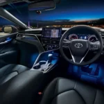 Toyota Camry interior dashboard view with touchscreen display and city lights visible through windshield