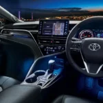 Toyota Camry interior dashboard view with touchscreen display and city lights visible through windshield
