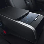Luxury rear seat armrest with touchscreen controls and climate settings in premium sedan interior cabin