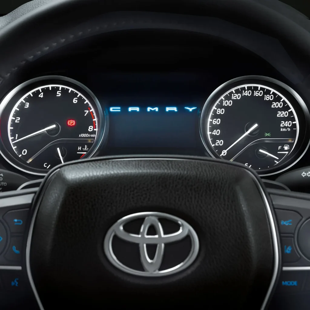 Driver view of Toyota dashboard gauges displaying rpm meter and speedometer with steering wheel logo visible