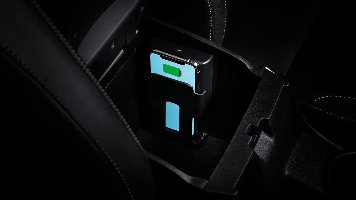 Toyota Fortuner wireless charging pad in center console compartment with smartphone showing green battery indicator