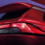 Toyota Corolla Cross rear taillight detail with LED technology and dramatic red illumination against dark background