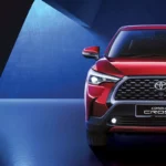 Red Toyota Corolla Cross front view in studio setting with dramatic blue lighting and bold grille design