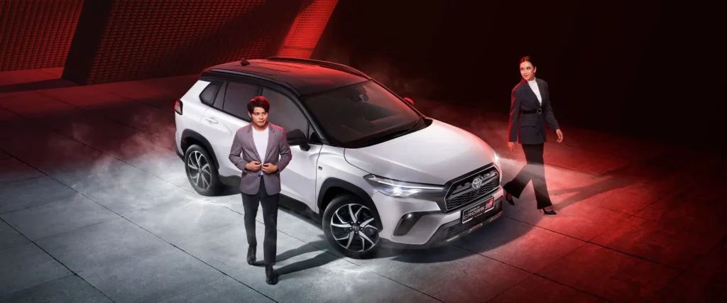 Toyota Corolla Cross GR Sport presentation with professional models in formal attire and dramatic red studio lighting
