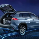 Toyota Corolla Cross Hybrid Electric with open tailgate showing cargo space against Kuala Lumpur city skyline