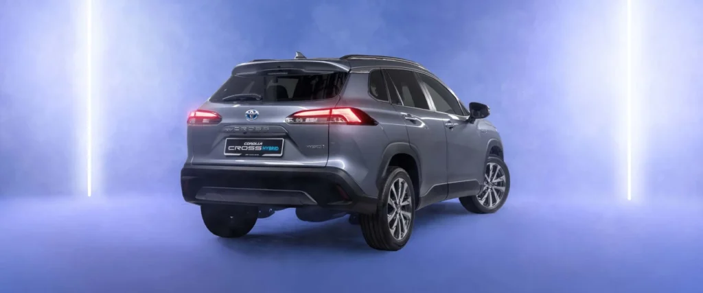 Toyota Corolla Cross Hybrid Electric rear three-quarter view in futuristic studio with purple gradient lighting