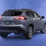 Toyota Corolla Cross Hybrid Electric rear three-quarter view in futuristic studio with purple gradient lighting