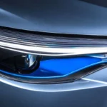 Close-up of Toyota Corolla Cross Hybrid Electric LED headlight featuring blue accent lighting and modern design