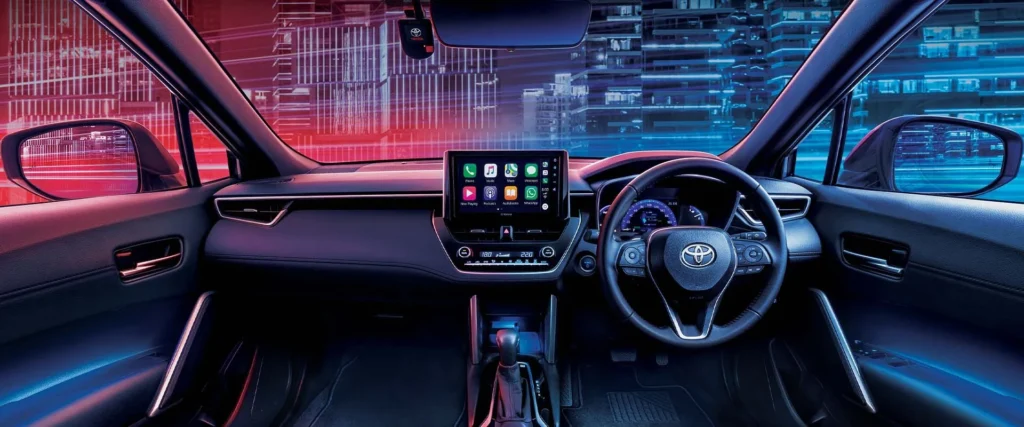 Modern Toyota Corolla Cross Hybrid Electric dashboard featuring touchscreen infotainment and urban skyline view