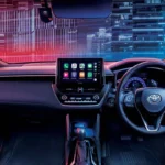 Modern Toyota Corolla Cross Hybrid Electric dashboard featuring touchscreen infotainment and urban skyline view