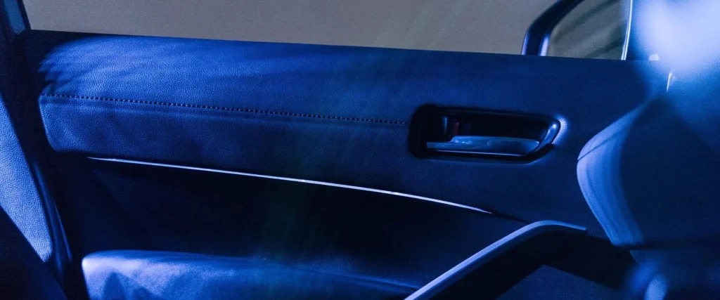 Interior door handle of Toyota Corolla Cross Hybrid Electric with illuminated accent lighting and premium interior trim