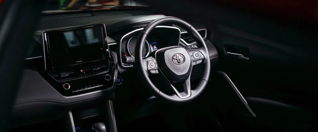 Toyota Corolla Cross dashboard driver view showing steering wheel controls and touchscreen infotainment system