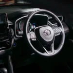 Toyota Corolla Cross dashboard driver view showing steering wheel controls and touchscreen infotainment system