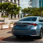 Back view of Toyota Corolla on the road with city view