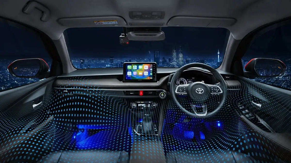 Toyota Vios interior dashboard with blue ambient lighting and touchscreen display overlooking city skyline