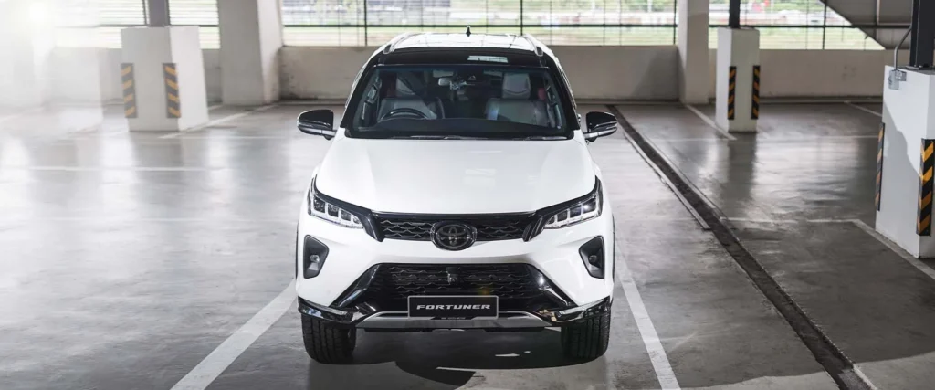 Toyota Fortuner positioned in contemporary parking structure showing bold grille design and LED headlight technology