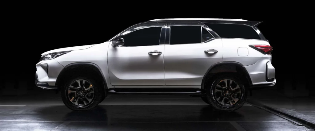 Toyota Fortuner positioned against dark background highlighting sleek body lines
