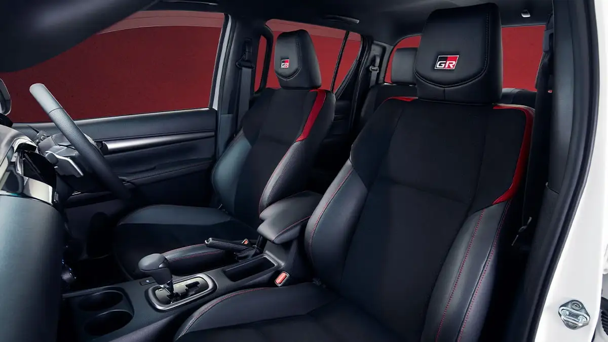 Toyota Hilux GR Sport front seats featuring black leather with red stitching and embossed GR logos on headrests