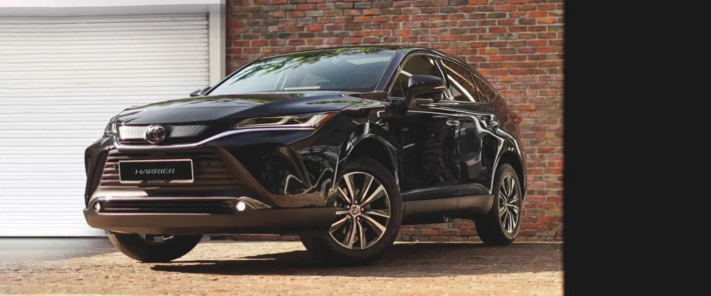 Toyota Harrier front exterior with distinctive grille design and chrome accents against brick wall background