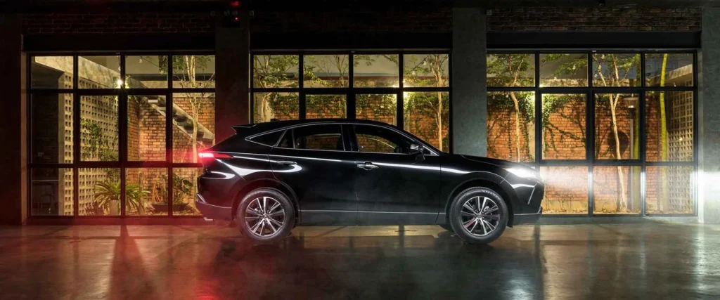 Black Toyota Harrier SUV positioned in contemporary glass showroom