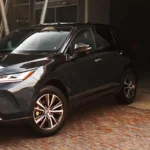 Toyota Harrier three-quarter front view in industrial warehouse setting with exposed steel beams and lighting