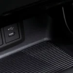 Close-up of Toyota Harrier dashboard featuring multiple charging ports and engine start button with textured trim