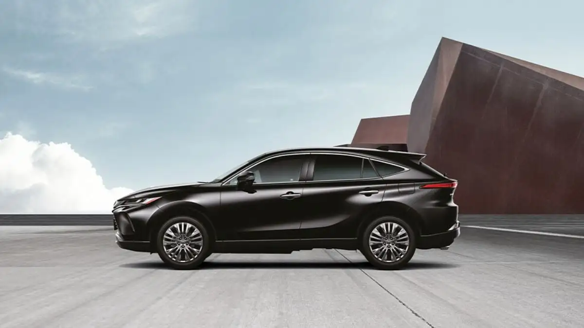 Black Toyota Harrier SUV side profile against modern architecture showcasing sleek crossover design and alloy wheels