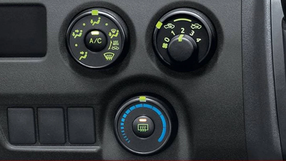 Toyota Hiace manual climate control system showing A/C, fan speed, and temperature dials with blue indicator lighting
