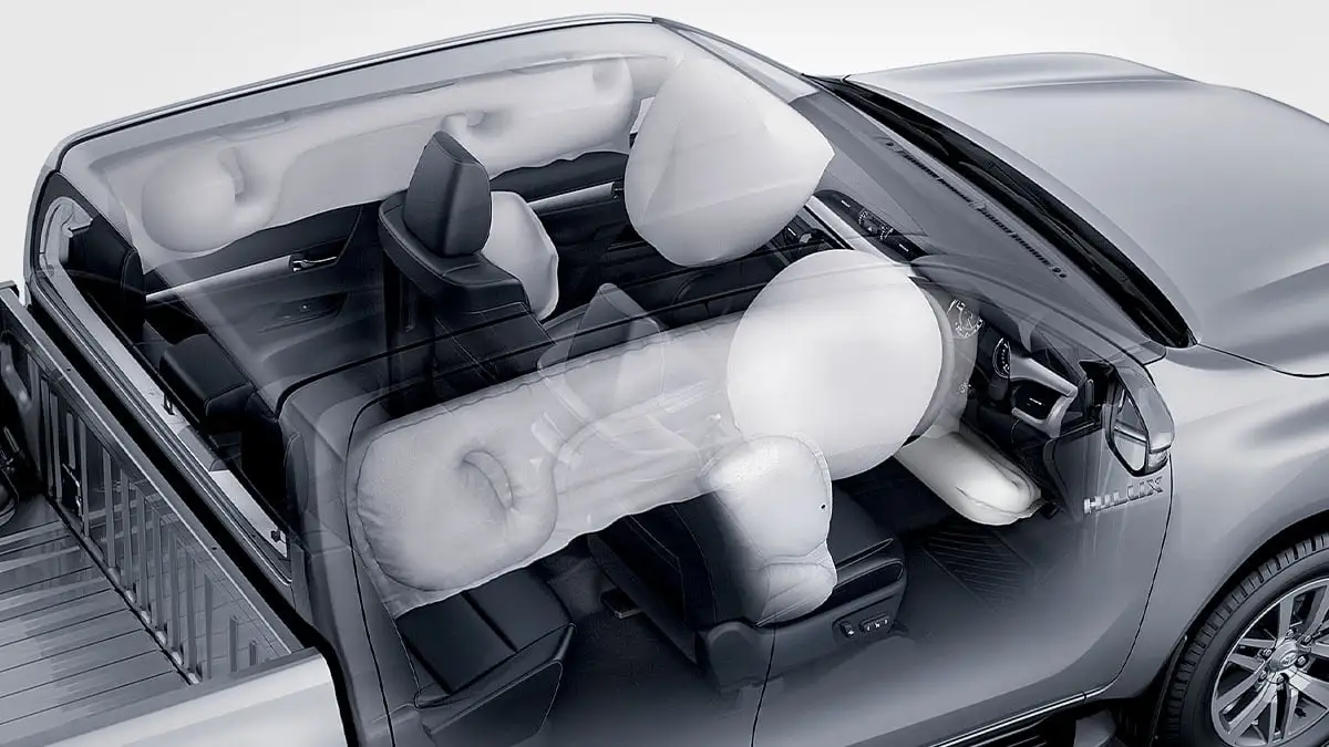 Toyota Hilux interior showing seven SRS airbag deployment with white airbags inflated throughout cabin for safety