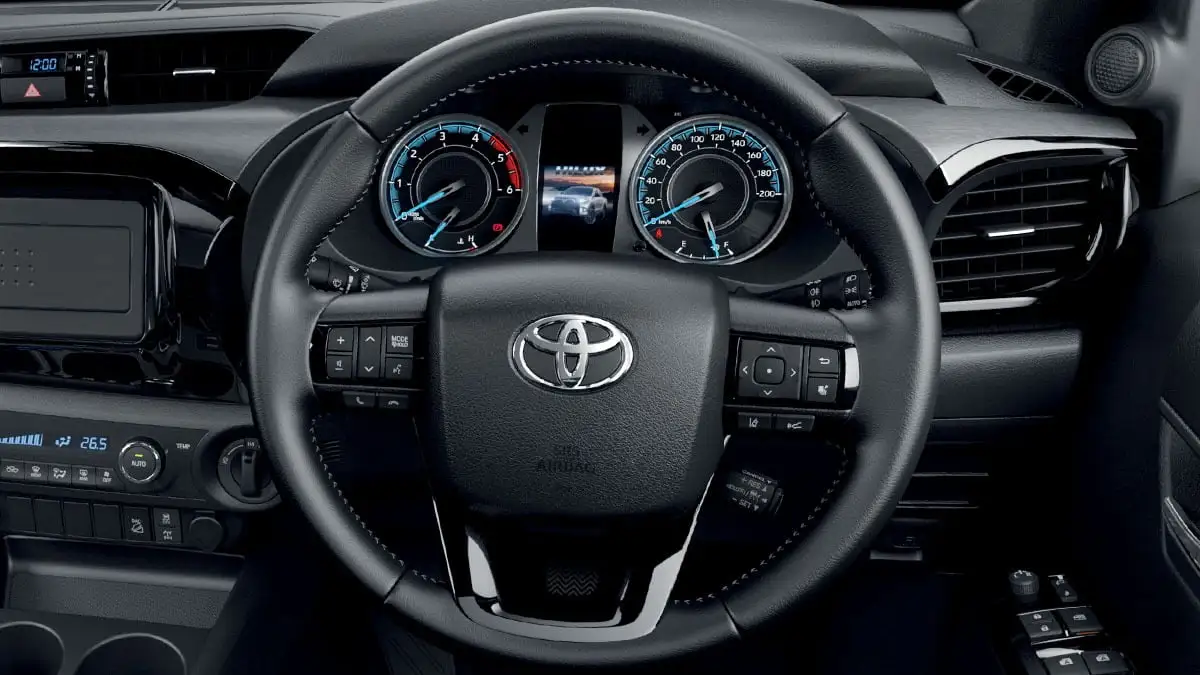 Toyota Hilux steering wheel with VFC power steering showing mounted controls and dual analog gauge cluster display