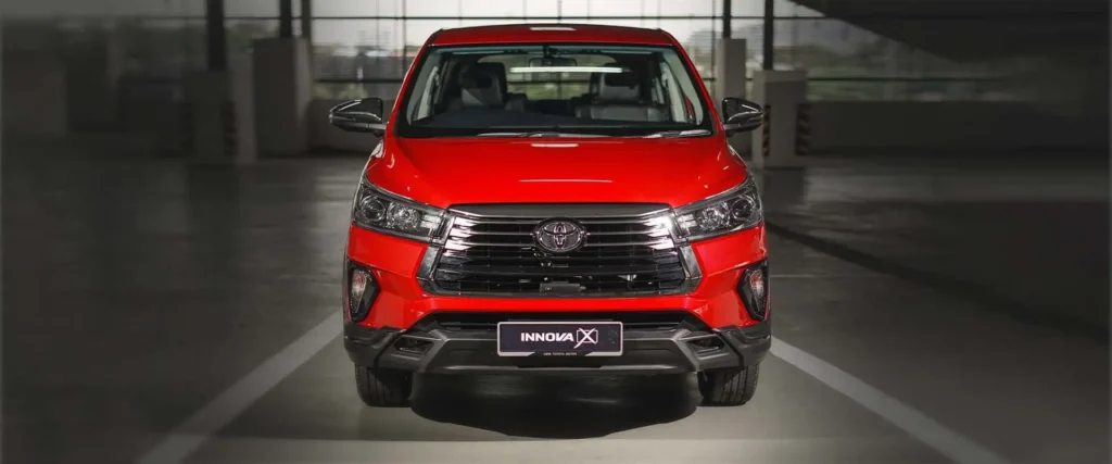 Front view of red Toyota Innova displaying bold grille design, LED headlights, and rugged bumper styling