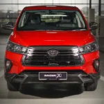 Front view of red Toyota Innova displaying bold grille design, LED headlights, and rugged bumper styling