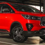 Red Toyota Innova parked in industrial setting showcasing bold exterior styling and premium wheel design