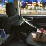 Toyota Innova spacious second-row interior featuring reclining seats, armrest with cup holders, and city view