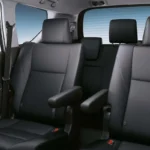 Toyota Innova three-row seating configuration with gray leather upholstery and wood grain trim accents