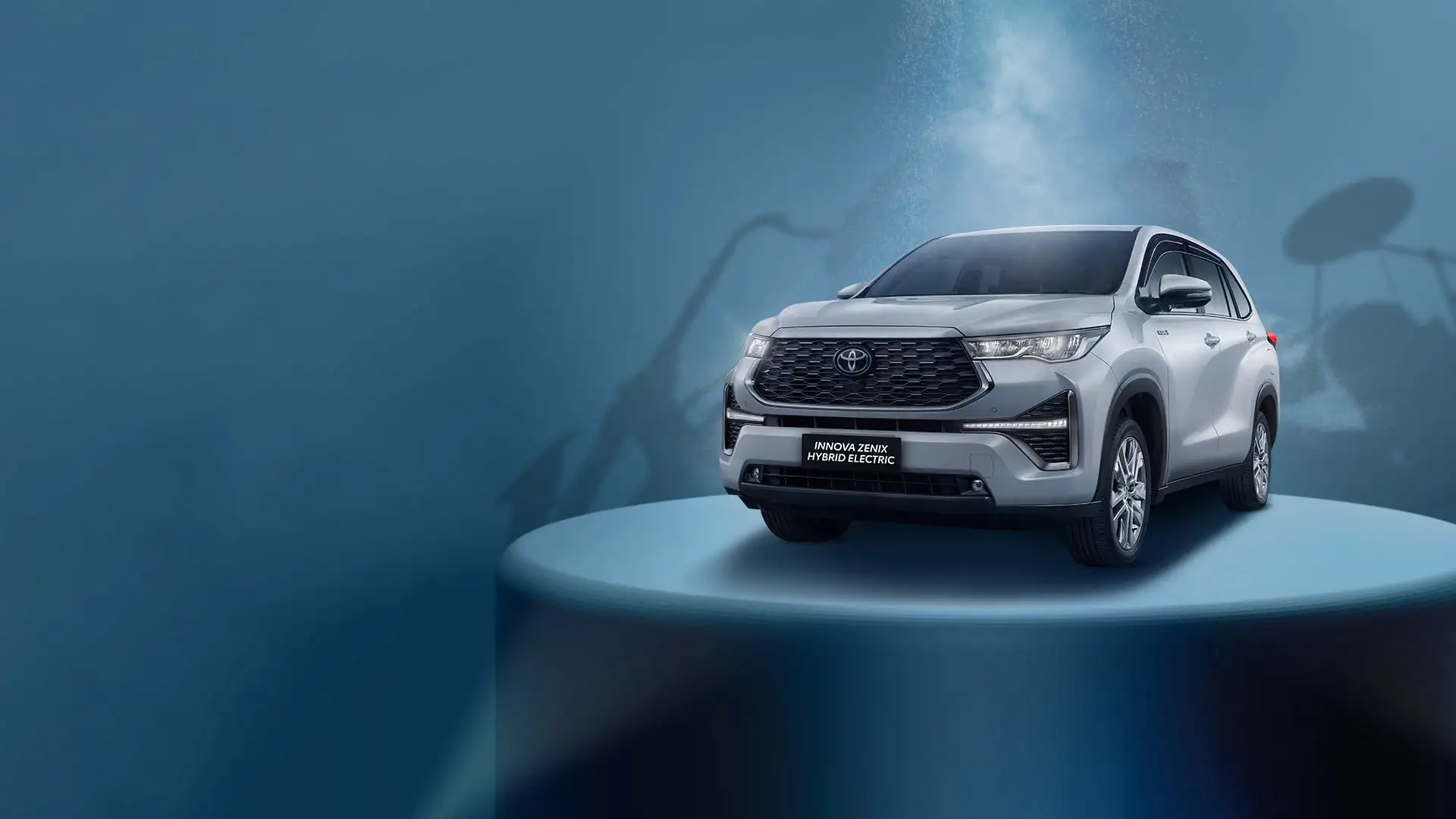 Red Toyota Innova Zenix Hybrid Electric with modern design featuring chrome grille and alloy wheels on dynamic blue background