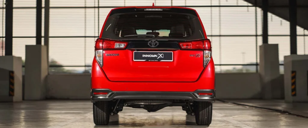 Rear view of red Toyota Innova showcasing tailgate design, brake lights, and modern proportions