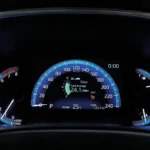 Modern Toyota Corolla dashboard showing tank average fuel consumption readout and trip computer information