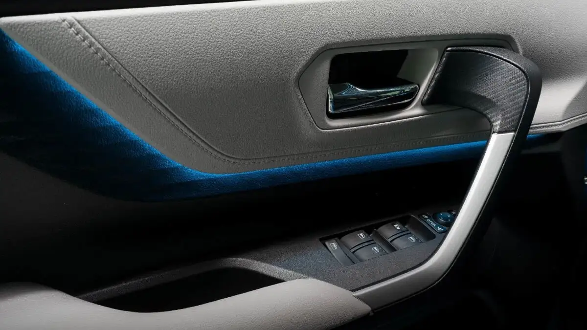 Toyota Veloz interior door panel featuring LED ambient lighting with blue accent strip and window controls