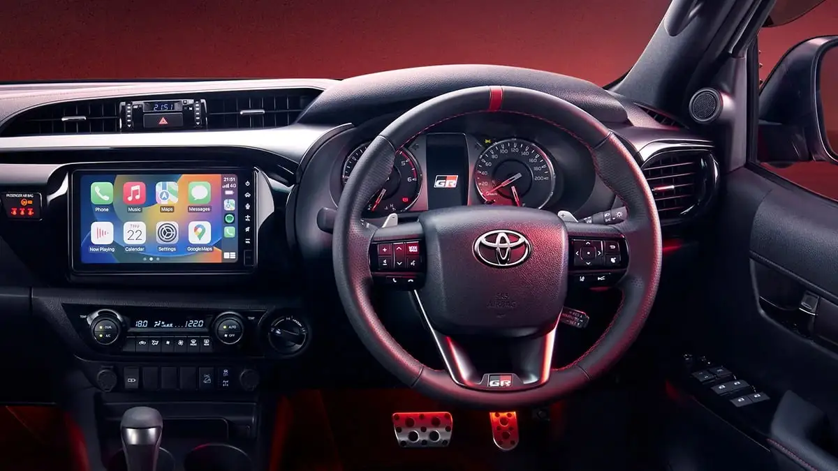 Toyota Hilux GR Sport sporty interior featuring steering wheel and performance pedals with touchscreen display