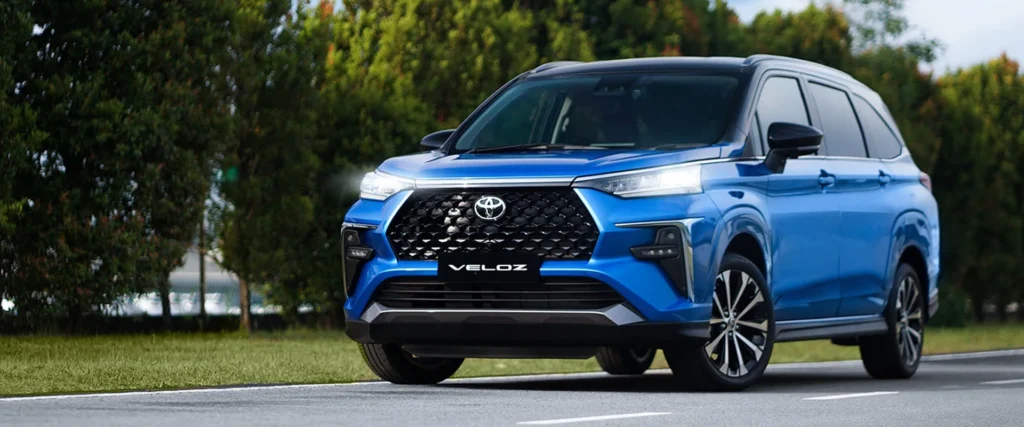 Toyota Veloz blue with distinctive front grille design parked on road with nature background
