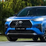 Toyota Veloz blue with distinctive front grille design parked on road with nature background
