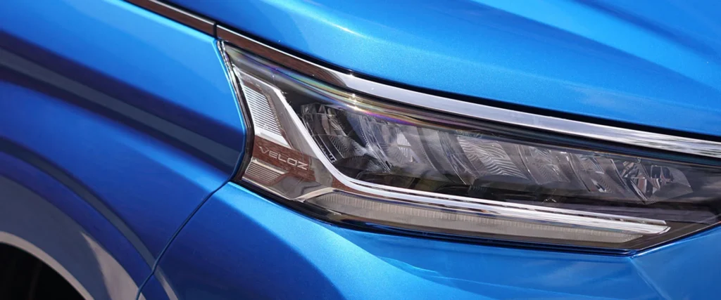 Toyota Veloz blue vehicle headlight macro view highlighting advanced lighting technology and styling elements