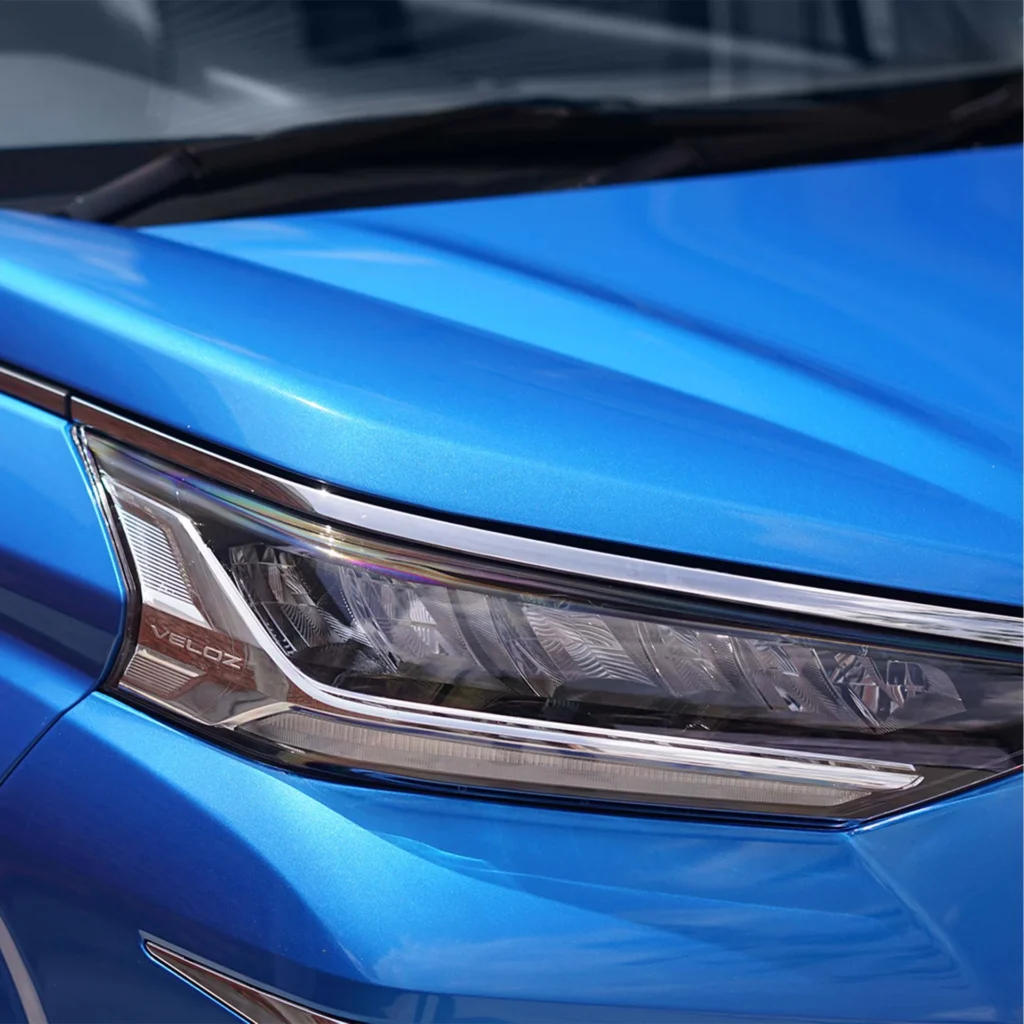 Toyota Veloz blue vehicle headlight macro view highlighting advanced lighting technology and styling elements