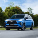 Toyota Veloz blue SUV with distinctive front grille design parked on road with nature background