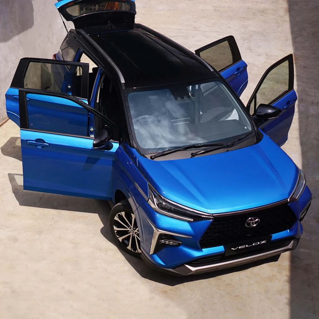 Toyota Veloz blue vehicle displayed with open doors and trunk showcasing interior space and accessibility