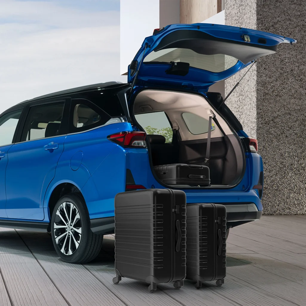 Blue Toyota Veloz SUV with open tailgate displaying cargo space and travel luggage on concrete surface
